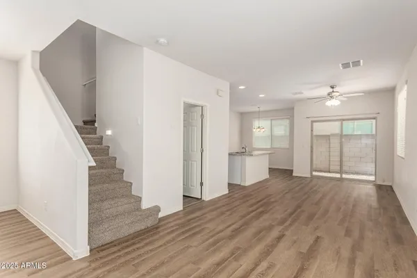 a view of a livingroom with wooden floor and staircase