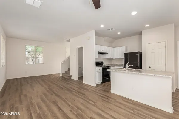 a view of kitchen with stainless steel appliances refrigerator stove microwave and cabinets