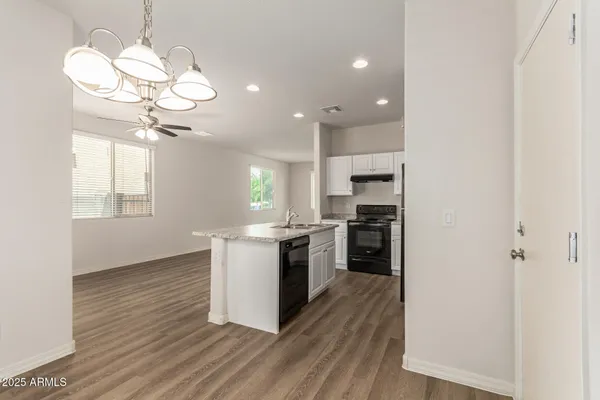 a kitchen with wooden floors and white cabinets