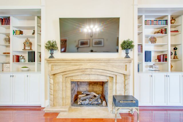 a kitchen with stainless steel appliances granite countertop a refrigerator a stove top oven and a dining table with wooden floor