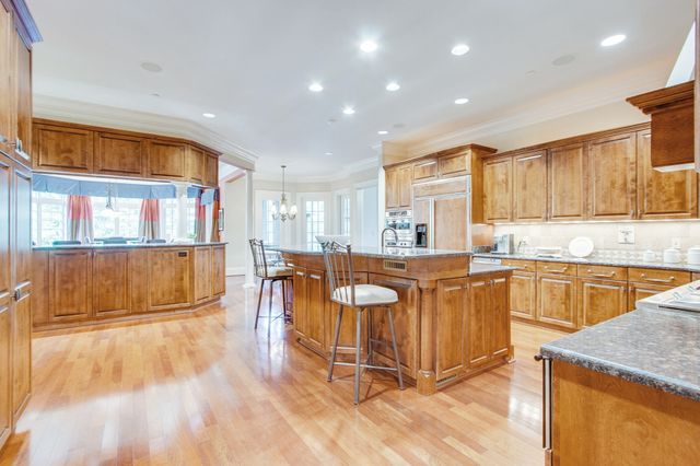 a kitchen with stainless steel appliances granite countertop a sink a stove and a wooden cabinets