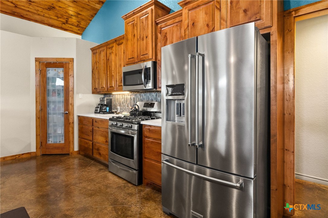 381 Schneider Road Seguin, TX 78155 - Photo 11 of 46 a kitchen with stainless steel appliances a refrigerator a stove top oven a sink and dishwasher