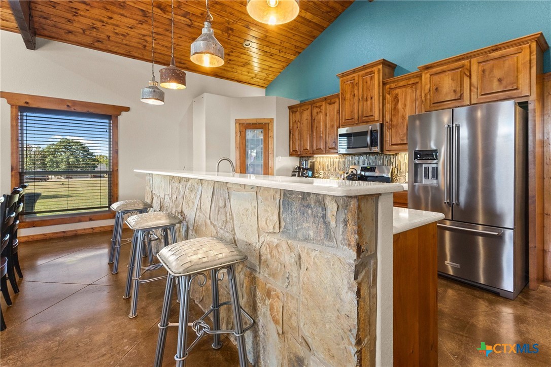 381 Schneider Road Seguin, TX 78155 - Photo 12 of 46 a kitchen with stainless steel appliances a refrigerator a stove a dining table and chairs with wooden floor