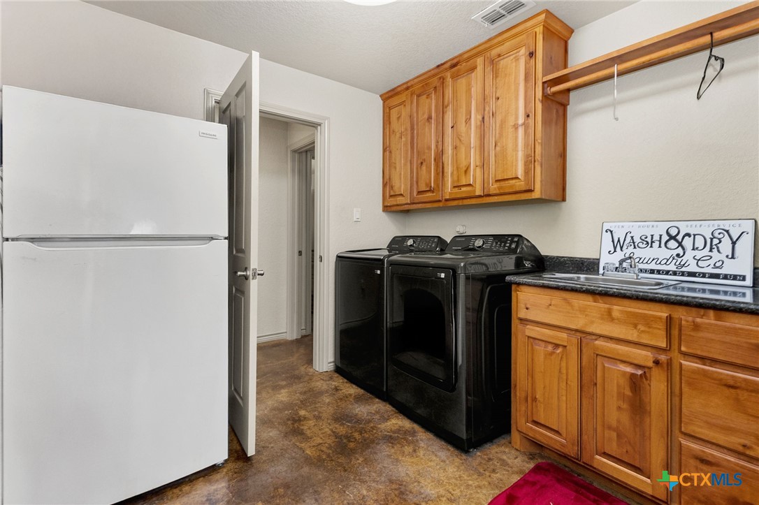 381 Schneider Road Seguin, TX 78155 - Photo 18 of 46 a utility room with refrigerator and cabinets