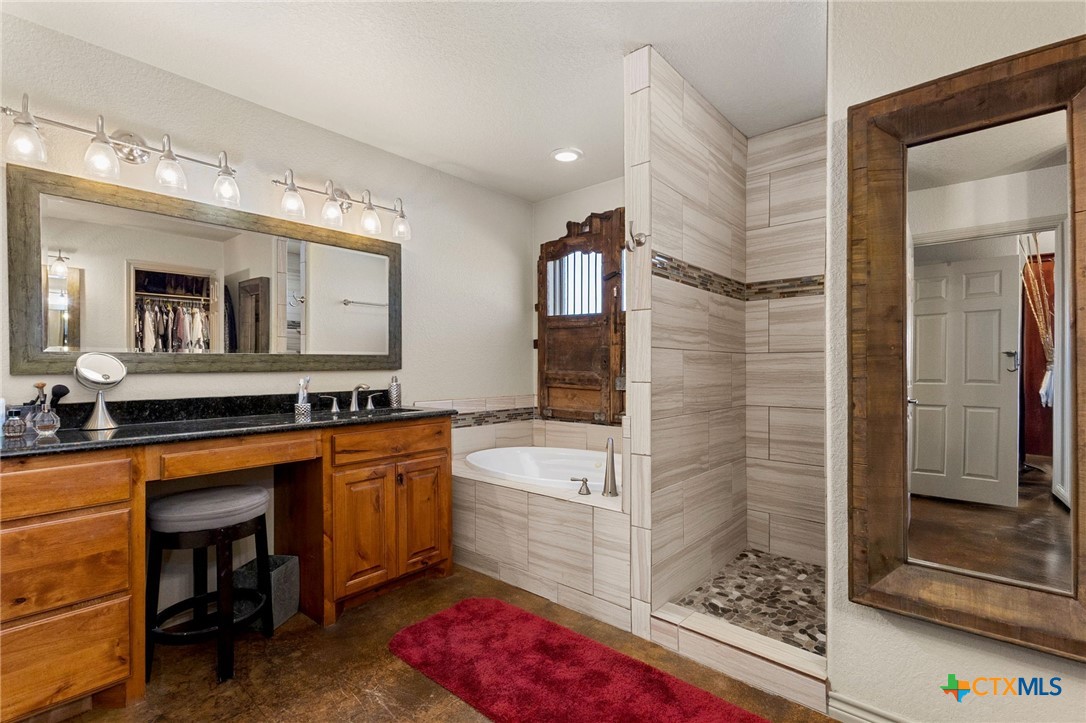 381 Schneider Road Seguin, TX 78155 - Photo 21 of 46 a spacious bathroom with a sink a large mirror and a bathtub