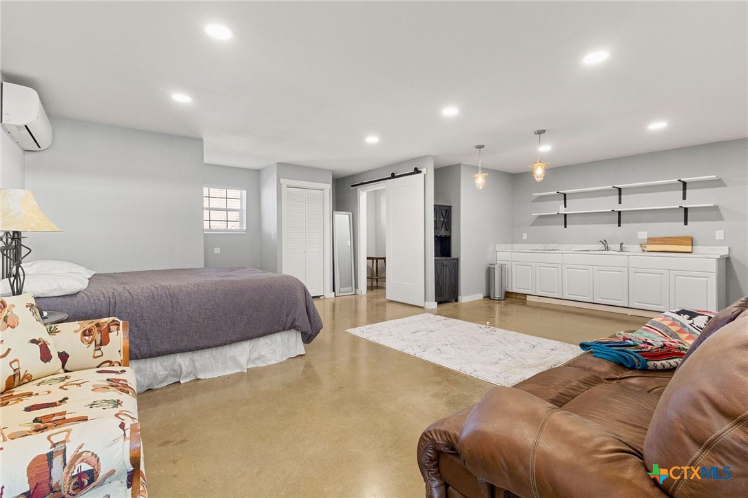 381 Schneider Road Seguin, TX 78155 - Photo 36 of 46 a bedroom with a bed and a refrigerator