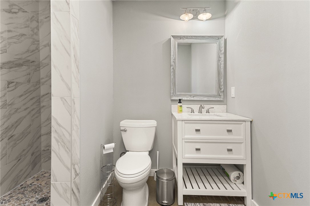 381 Schneider Road Seguin, TX 78155 - Photo 39 of 46 a bathroom with a toilet sink and mirror