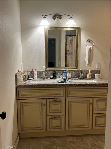 a bathroom with a granite countertop toilet and a sink