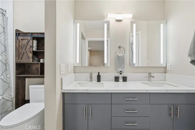 a bathroom with a double vanity sink mirror and toilet