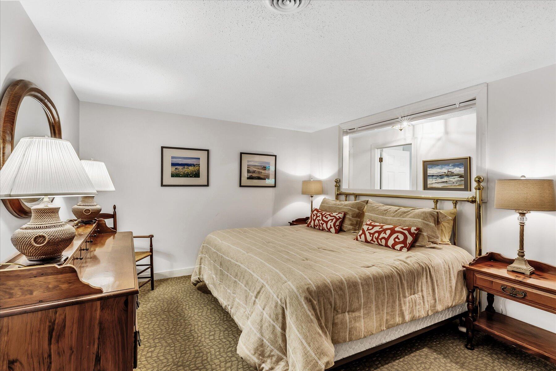 42 Wood Road Mashpee, MA 02649 - Photo 42 of 50 a spacious bedroom with a bed a lamp and a large window