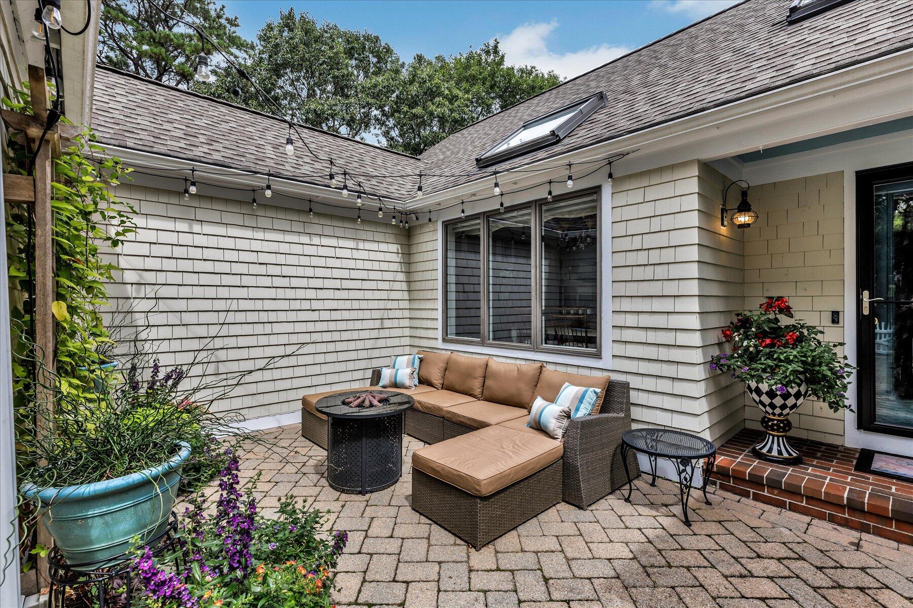 42 Wood Road Mashpee, MA 02649 - Photo 5 of 50 a view of a patio with couches chairs potted plants and water fountain