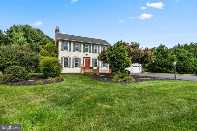 a view of a house with a big yard and large trees