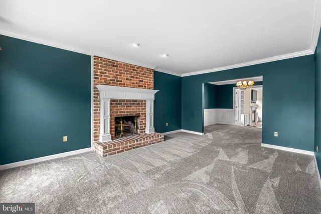 an empty room with windows and chandelier