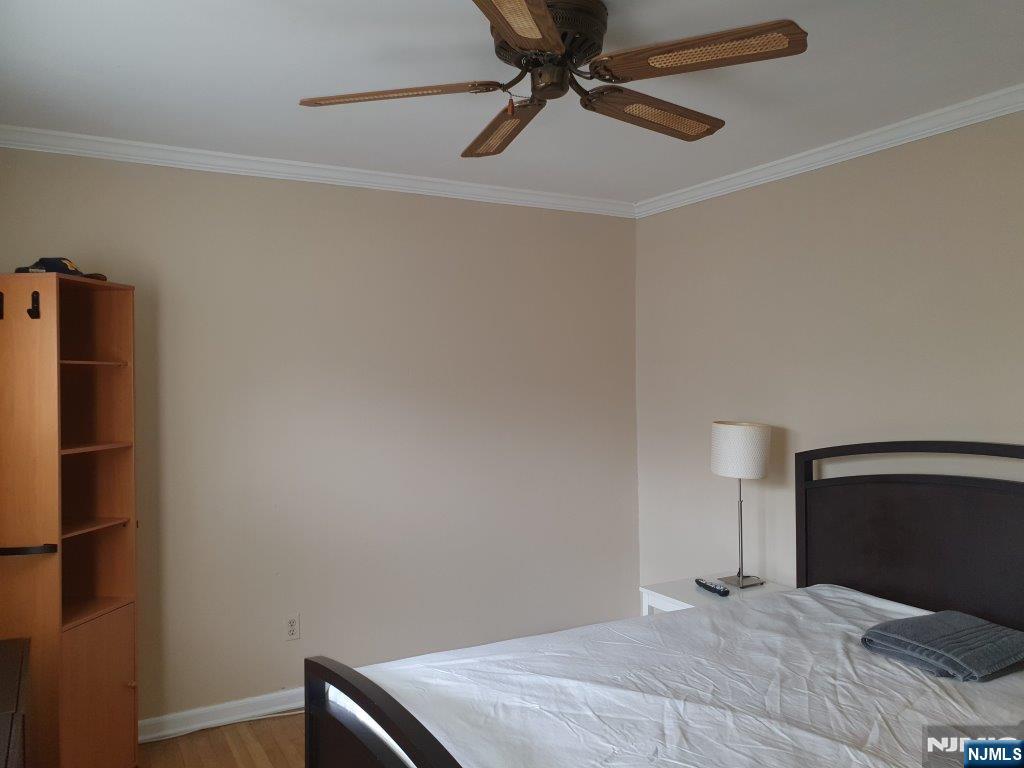 180 Atlantic Street Paterson, NJ 07503 - Photo 4 of 7 a bedroom with a bed and a fan