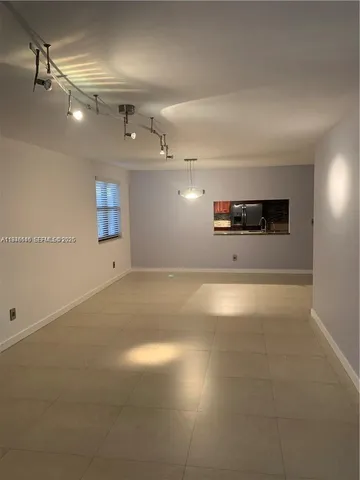 an empty room with ceiling fan and window