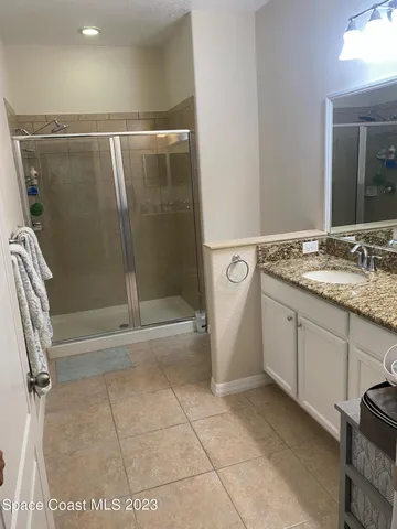 a bathroom with a granite countertop sink a toilet and shower