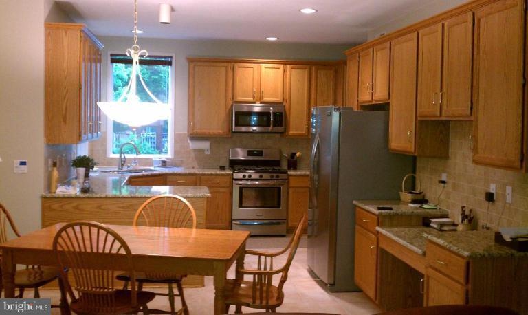 a kitchen with a table chairs microwave and refrigerator