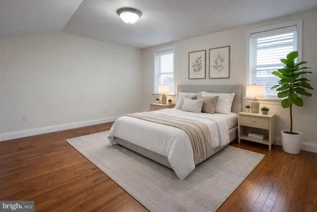 a bedroom with a large bed and a potted plant
