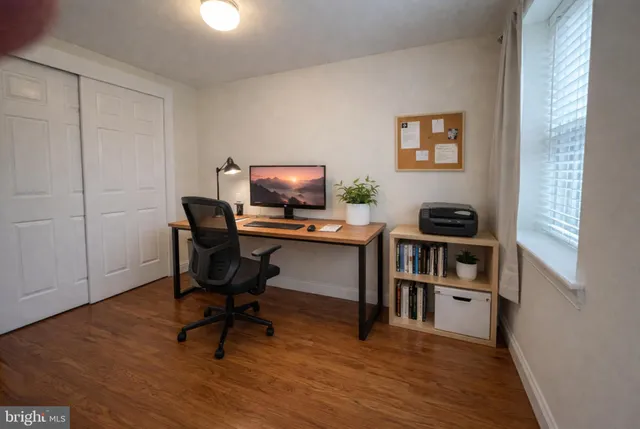 a view of a workspace with furniture and a window