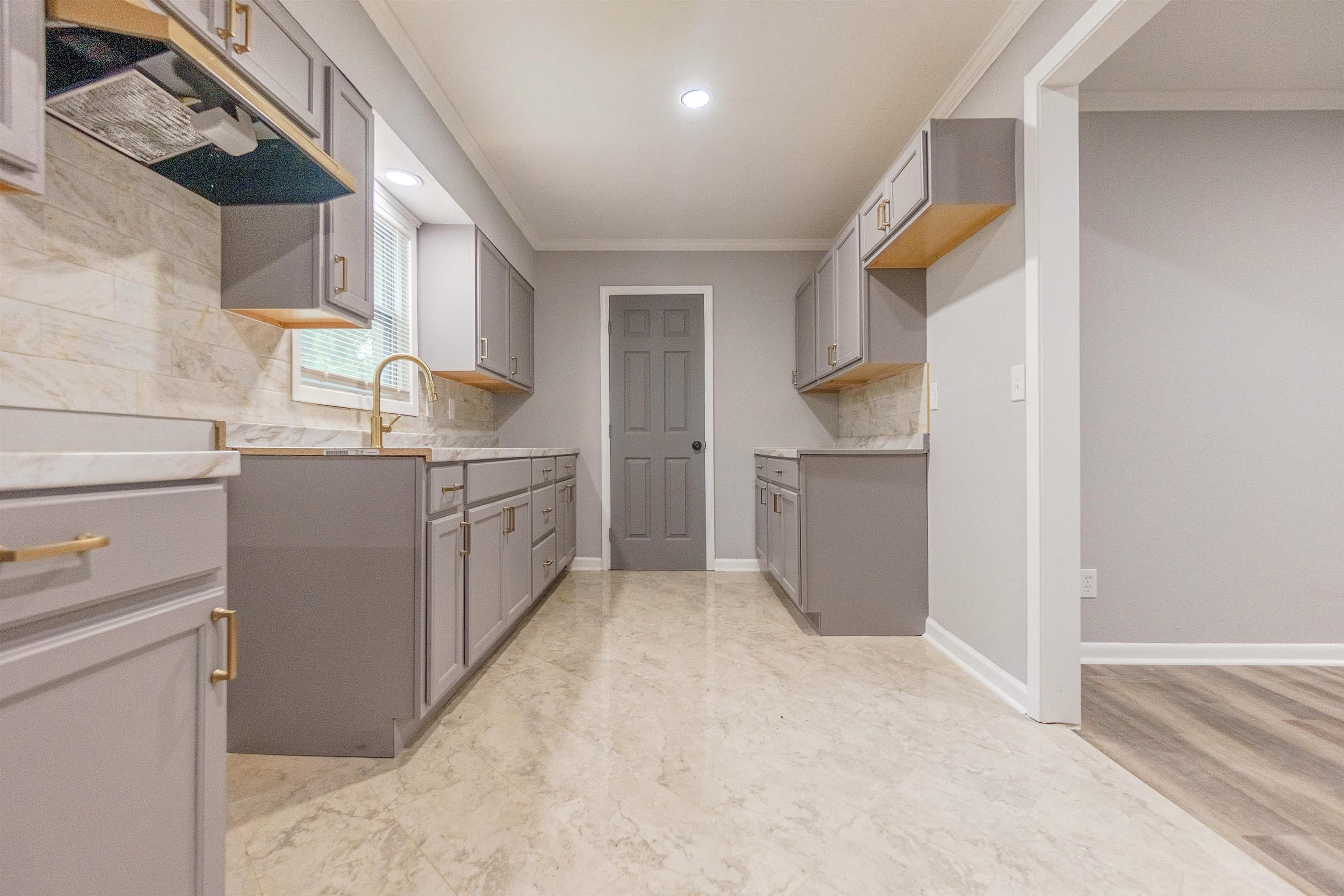 1011 Haledale Road Memphis, TN 38116 - Photo 13 of 25 a kitchen with a sink a stove and cabinets