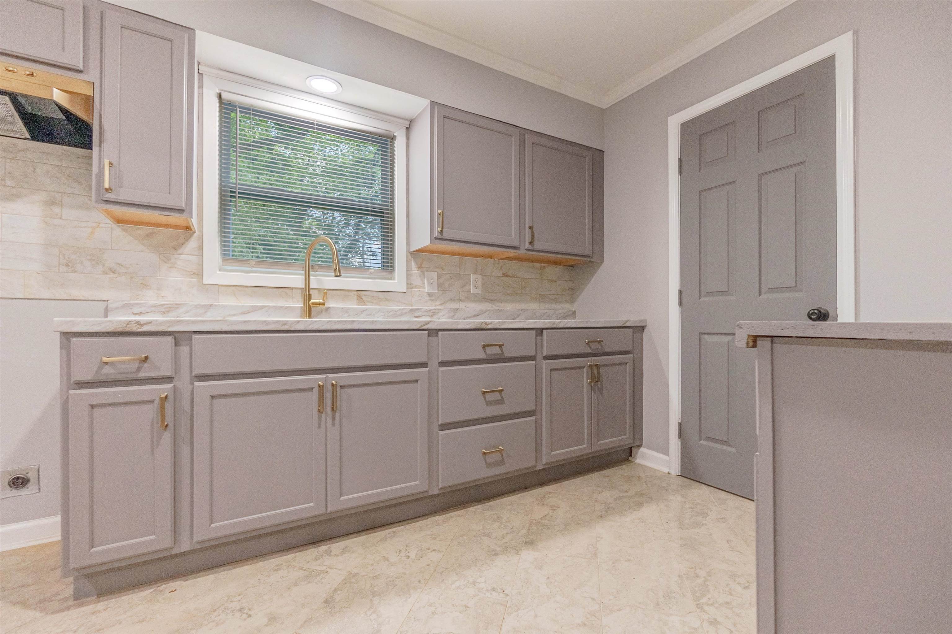 1011 Haledale Road Memphis, TN 38116 - Photo 14 of 25 a kitchen with white cabinets and sink