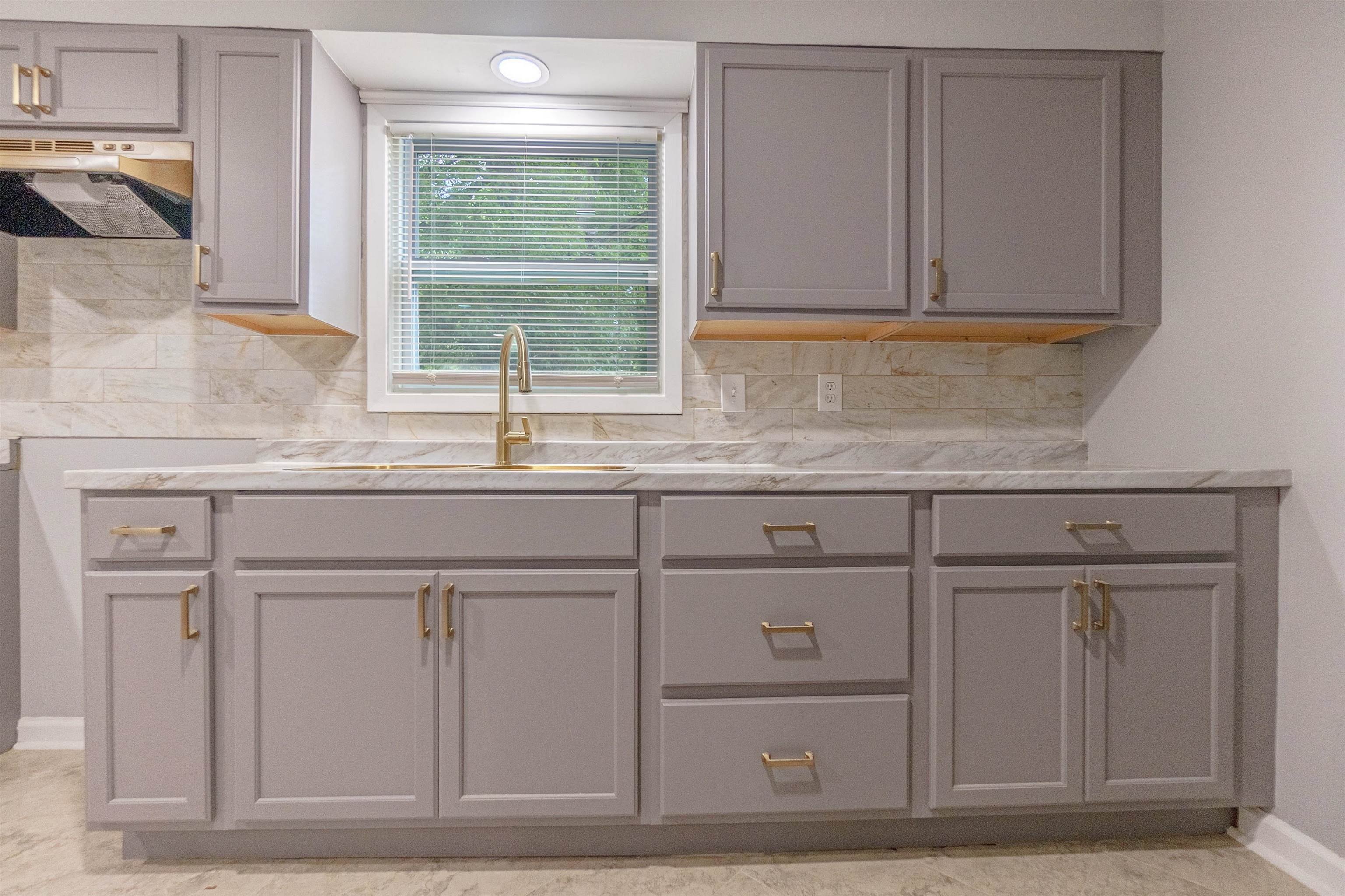 1011 Haledale Road Memphis, TN 38116 - Photo 15 of 25 a kitchen with granite countertop white cabinets and a sink