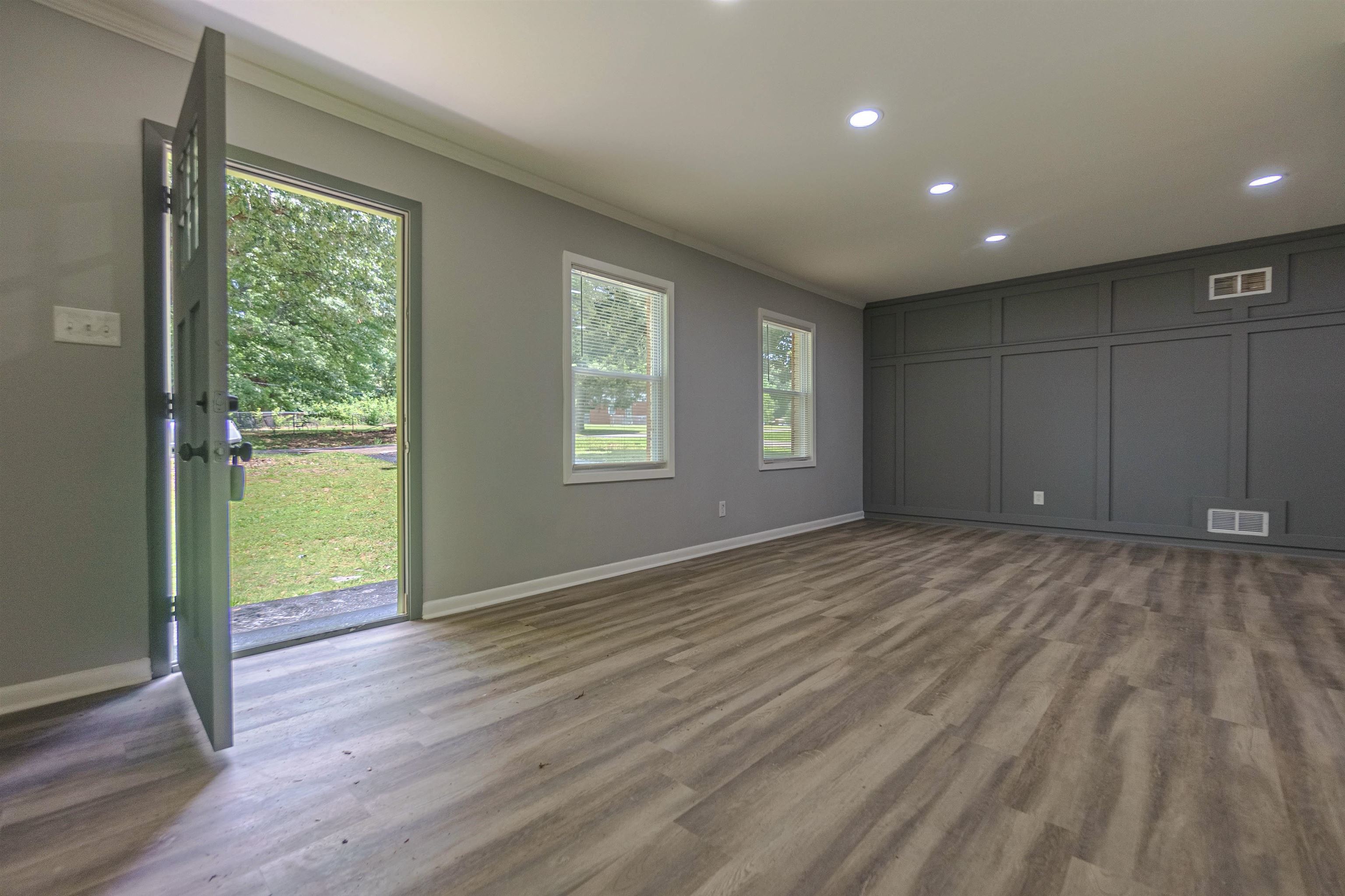 1011 Haledale Road Memphis, TN 38116 - Photo 6 of 25 a view of an empty room with wooden floor and a window