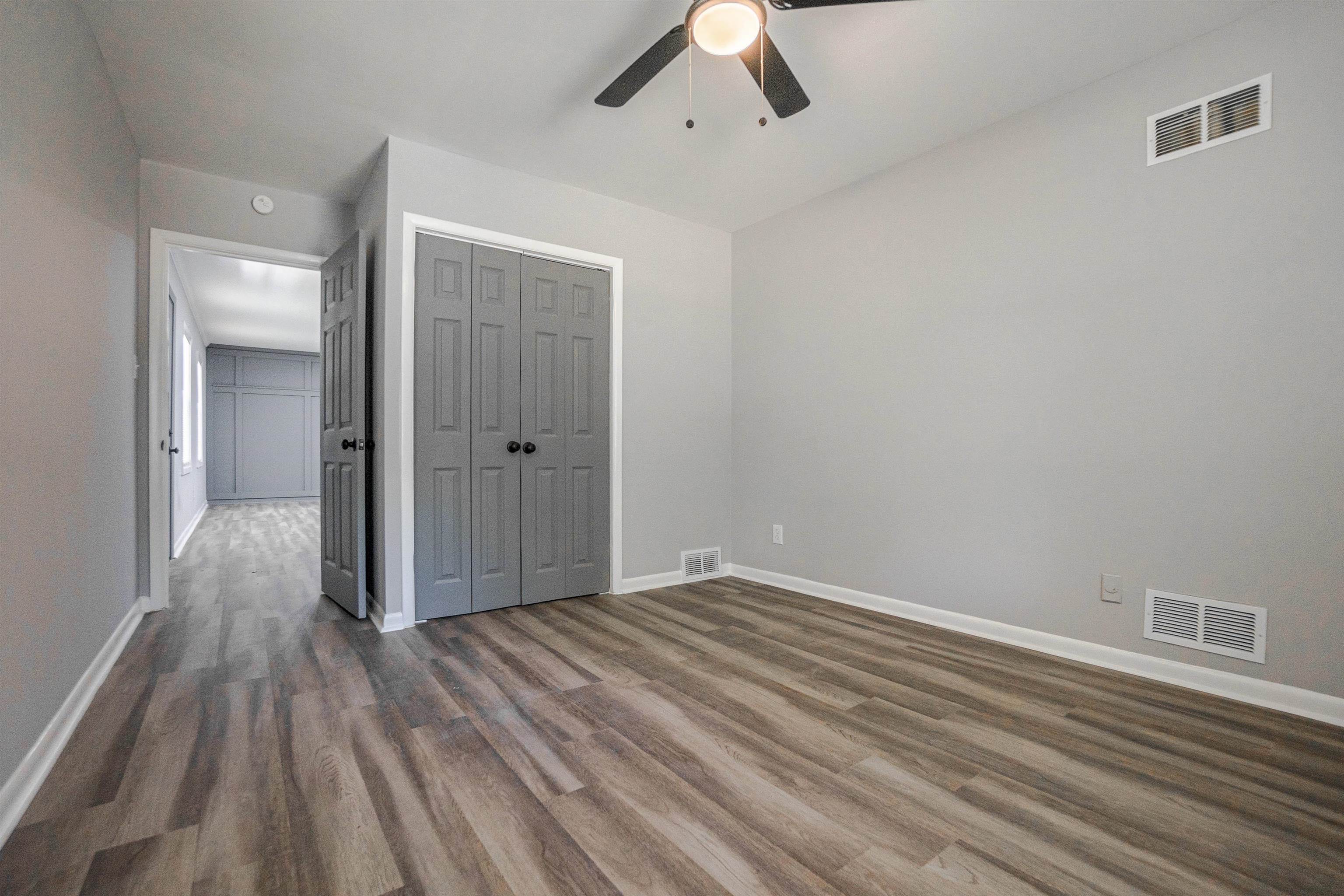 1011 Haledale Road Memphis, TN 38116 - Photo 7 of 25 an empty room with wooden floor and windows