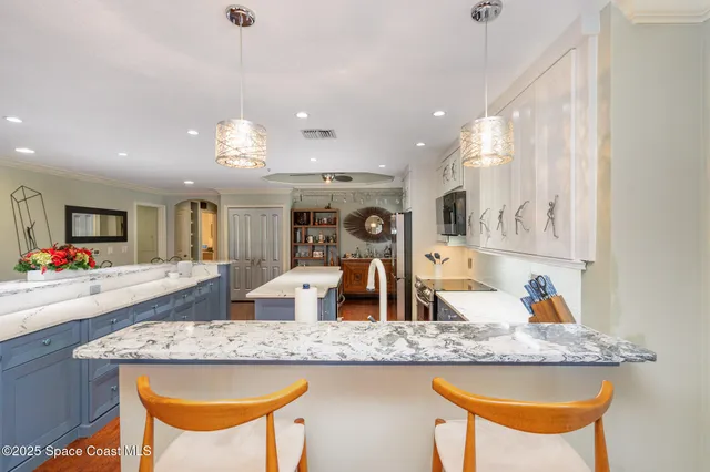 a kitchen with stainless steel appliances granite countertop a sink a stove a refrigerator and island