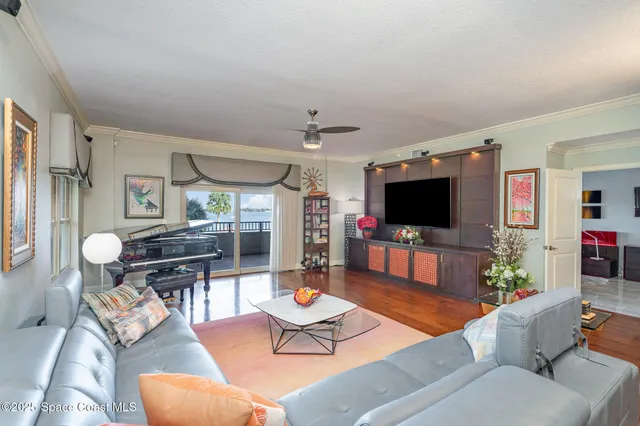 a living room with furniture kitchen view and a large window