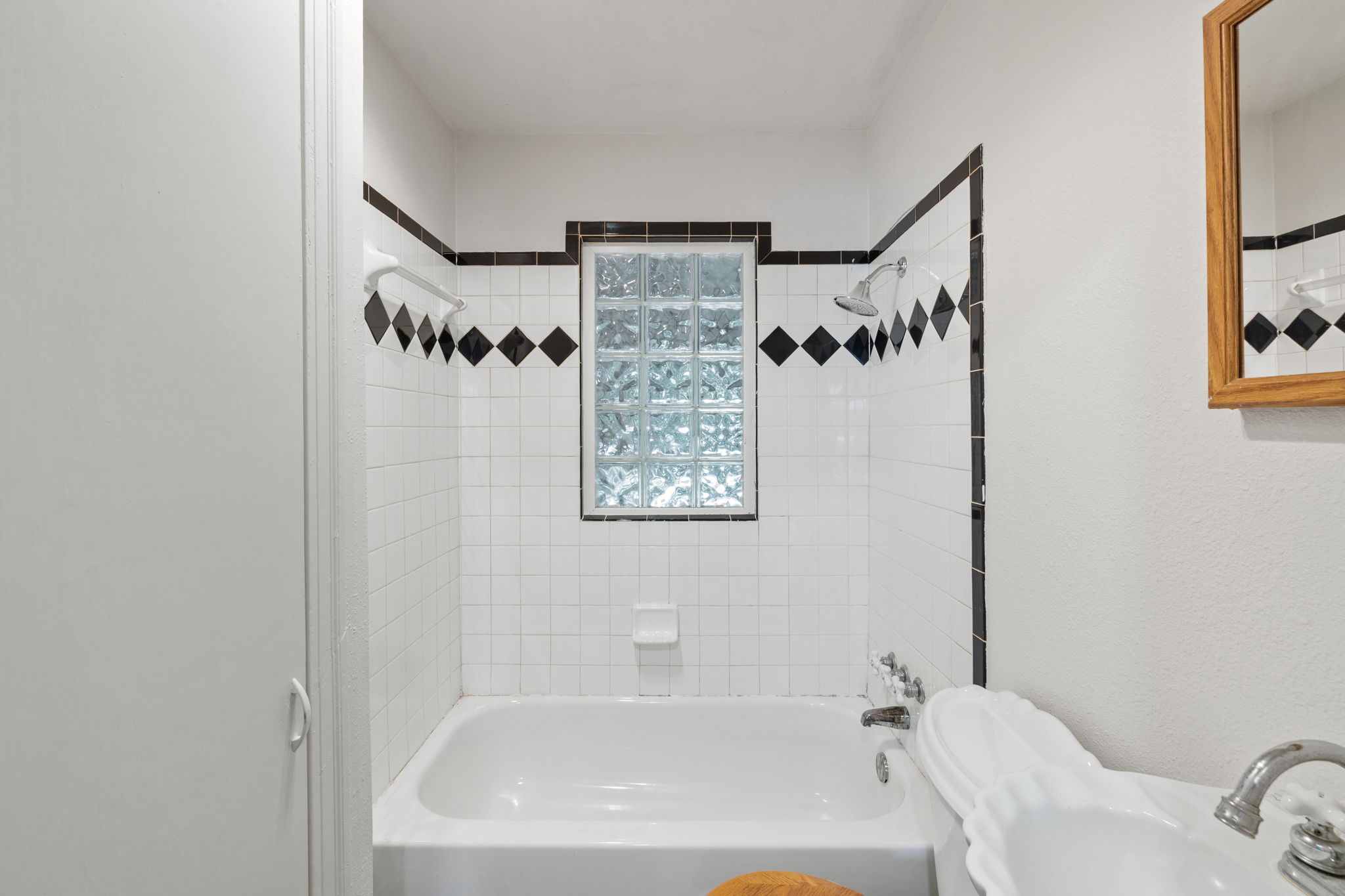 3704 Cherrywood Road Austin, TX 78722 - Photo 22 of 40 A well-lit bathroom with classic tilework and a linen closet.