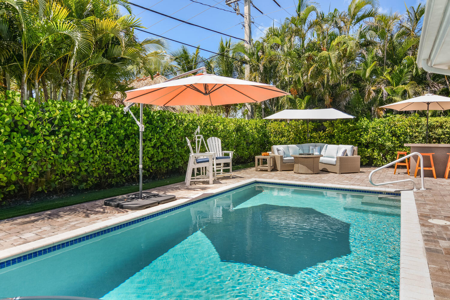 a view of a house with backyard sitting area and swimming pool