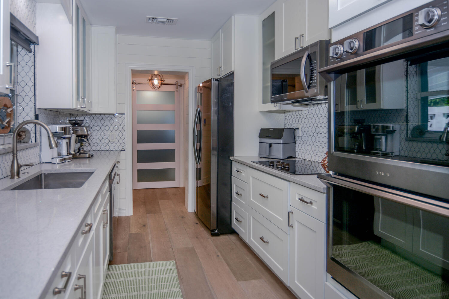 3396 Pebble Place Jupiter, FL 33469 - Photo 11 of 24 a kitchen with stainless steel appliances granite countertop a refrigerator a stove and a sink with wooden floors