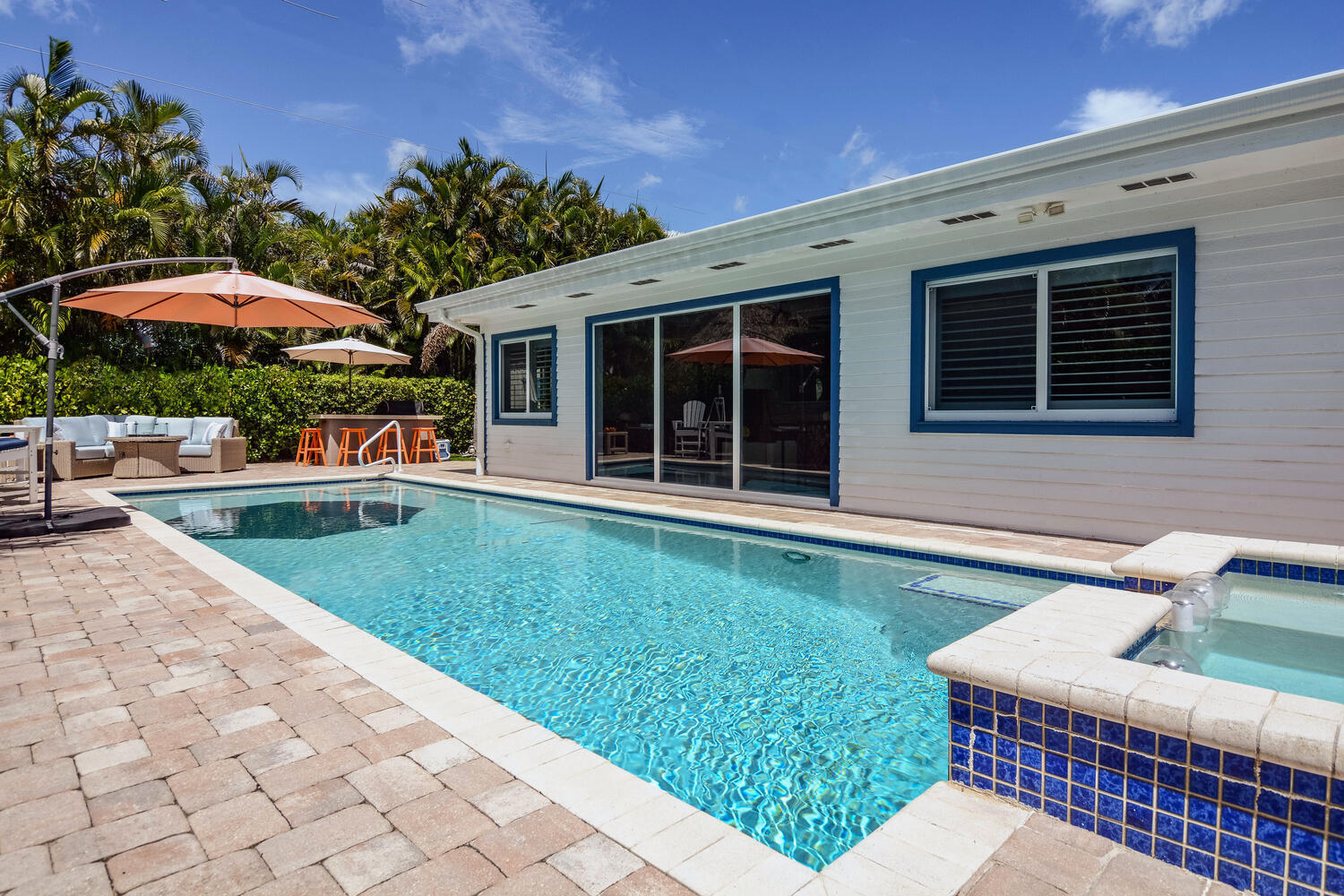 3396 Pebble Place Jupiter, FL 33469 - Photo 2 of 24 a view of a house with backyard sitting area and swimming pool