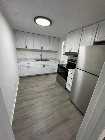 a kitchen with stainless steel appliances granite countertop a refrigerator sink and cabinets
