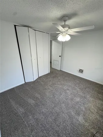 an empty room with fan and window