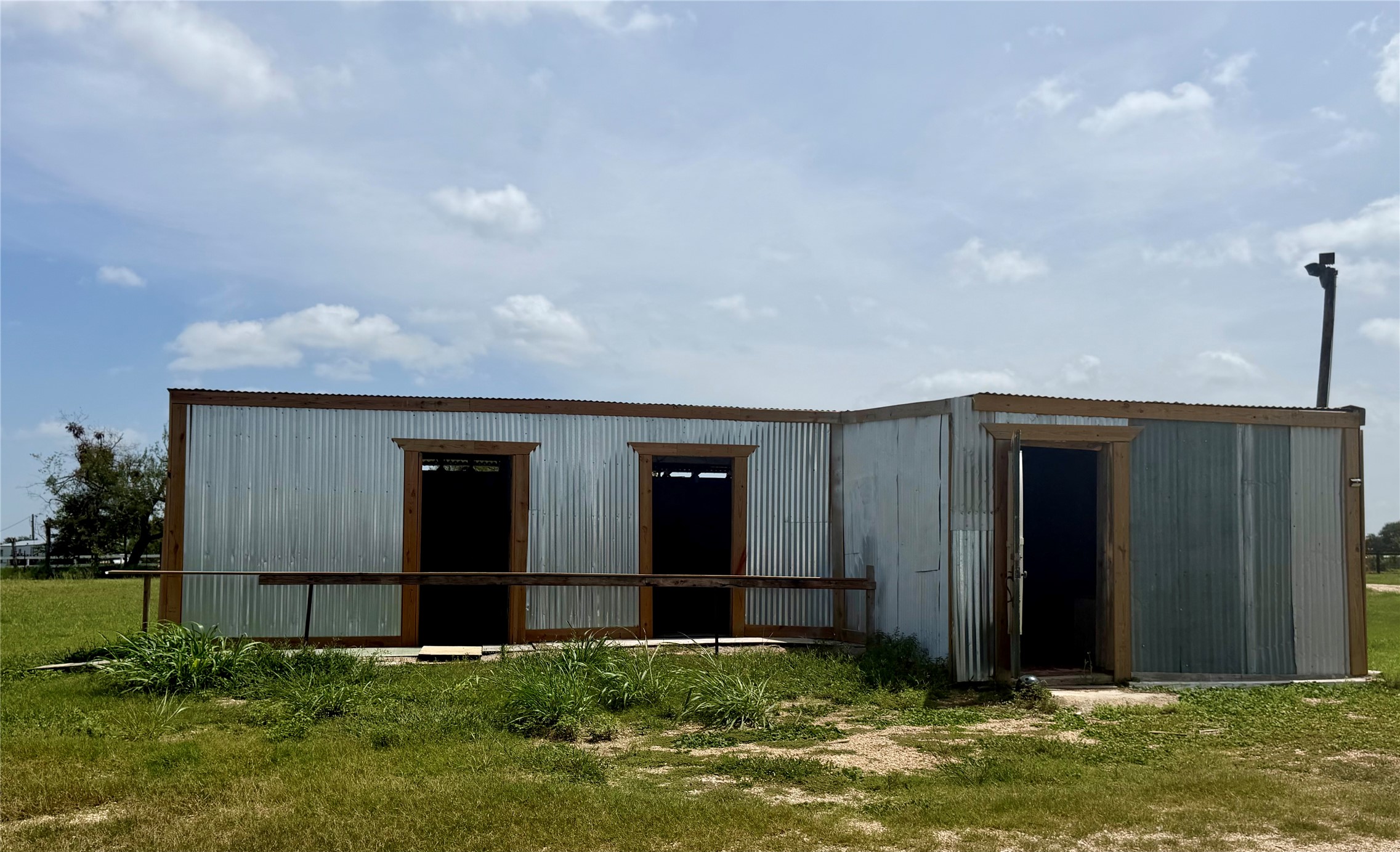 441 Molasses Road Dale, TX 78616 - Photo 30 of 36 A metal-sided structure awaits its next chapter, offering versatile space on a green lot.