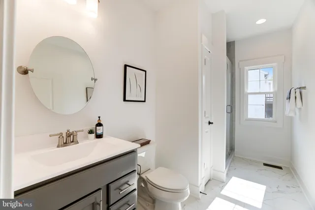 a bathroom with a sink a toilet and shower