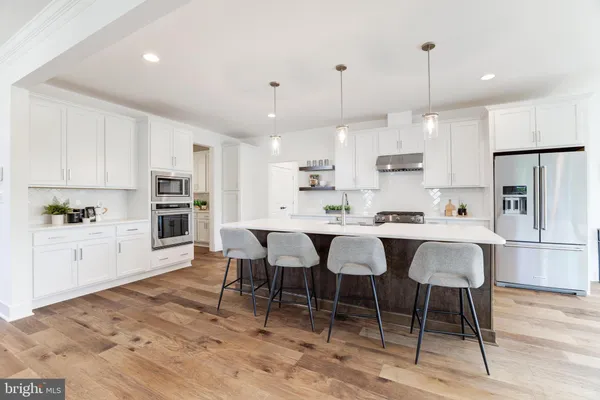 a large white kitchen with lots of counter space and dining table chairs