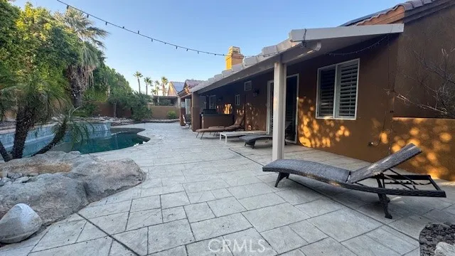 a backyard of a house with barbeque oven table and chairs