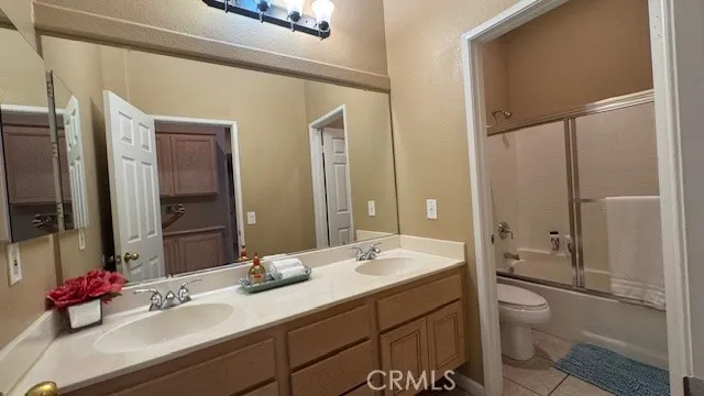 a bathroom with a double vanity sink toilet mirror and bathtub
