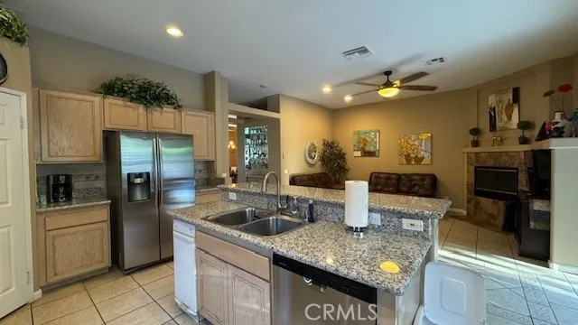 a kitchen with stainless steel appliances granite countertop a sink and a refrigerator