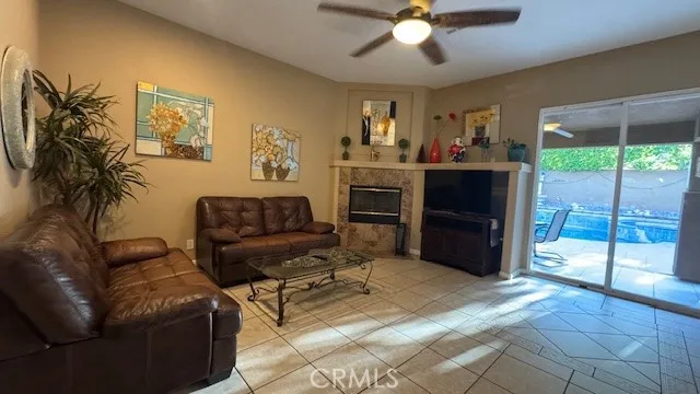 a living room with furniture a ceiling fan and a large window