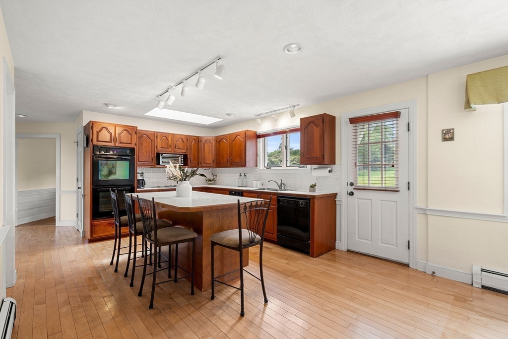 61 Turkey Hill Road West Newbury, MA 01985 - Photo 10 of 42 a kitchen with a table chairs and wooden floor