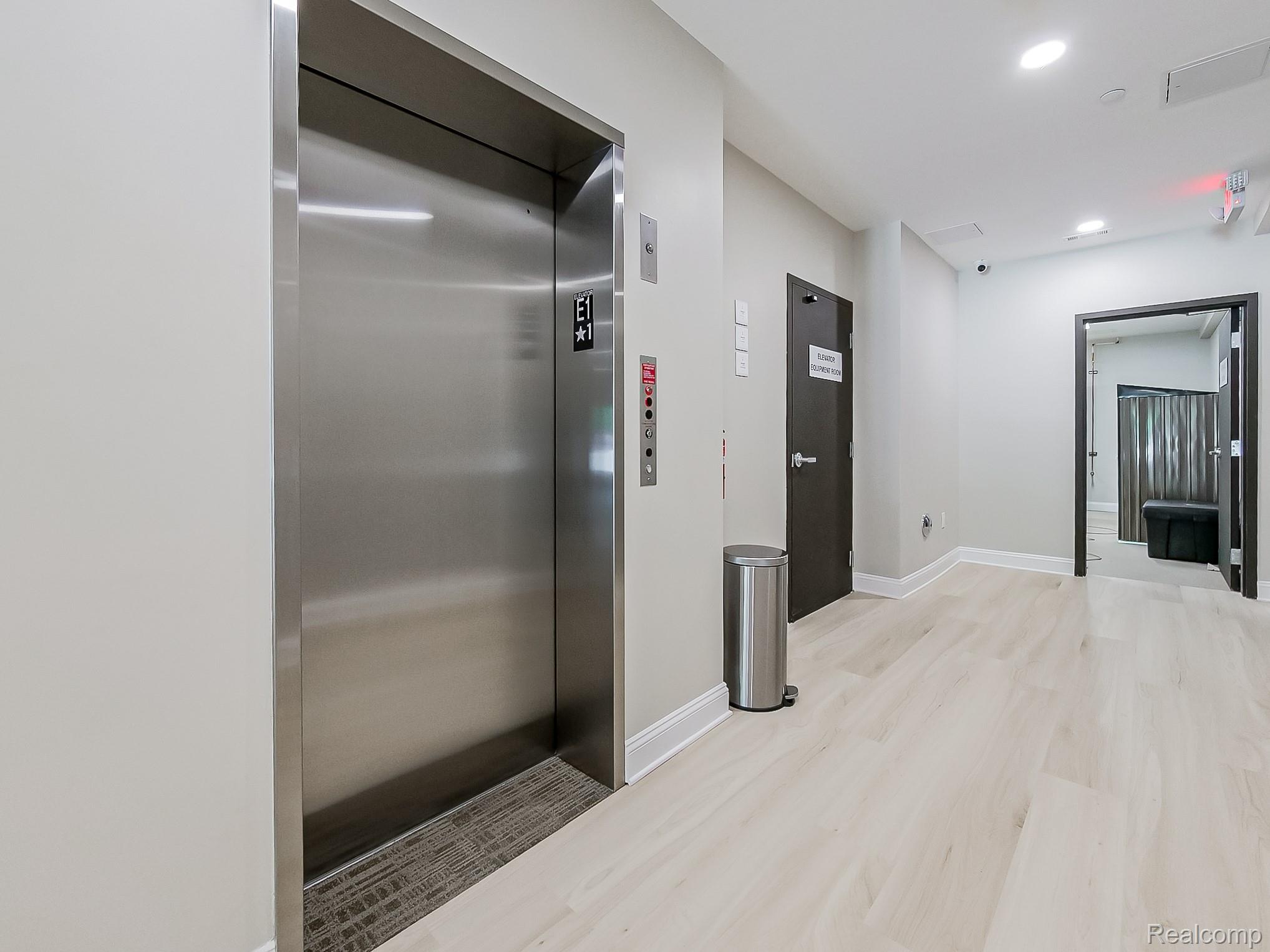 31480 Warren Road, Unit 101 Westland, MI 48185 - Photo 21 of 26 Hallway with elevator, light wood finished floors, and recessed lighting