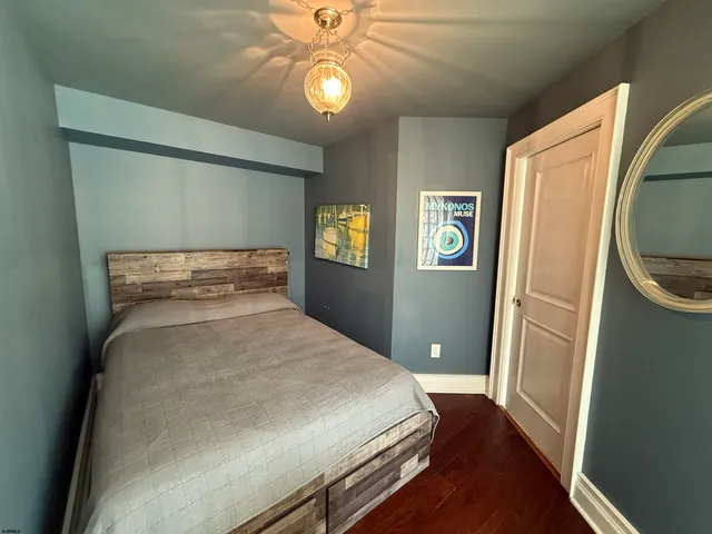a bedroom with a bed and painting on the wall