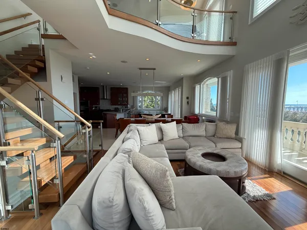 a living room with furniture kitchen view and a large window