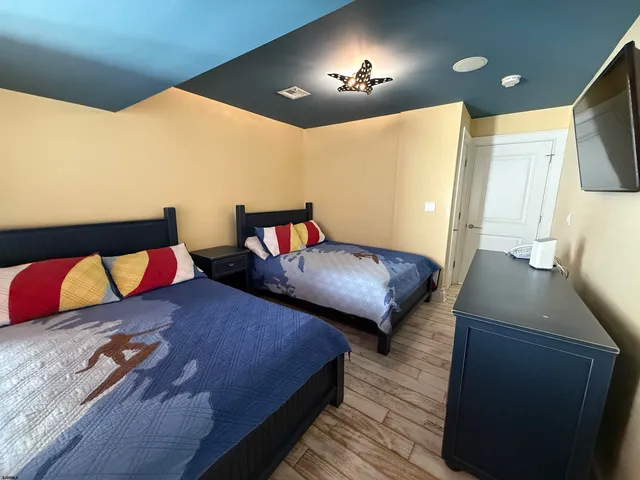 a bedroom with two beds and painting on the wall