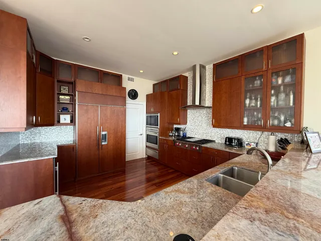 a large kitchen with granite countertop a refrigerator and a sink