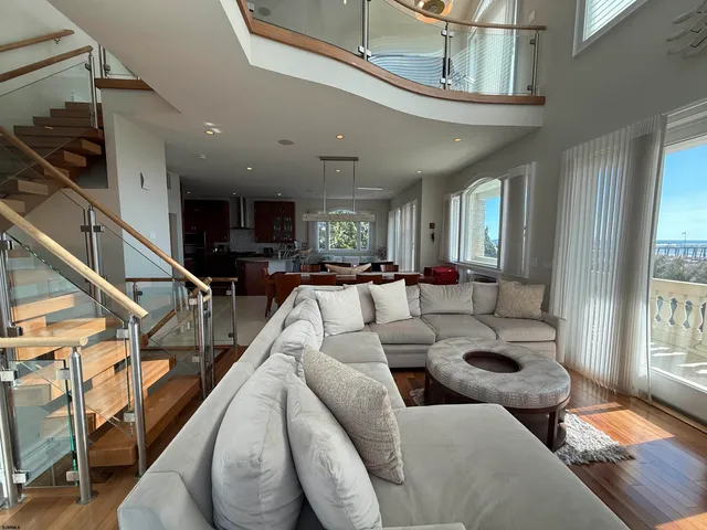 a living room with furniture kitchen view and a large window
